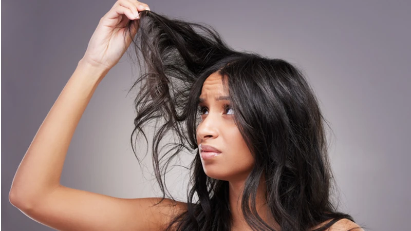 Woman following a hair care routine for oily hair with various hair products